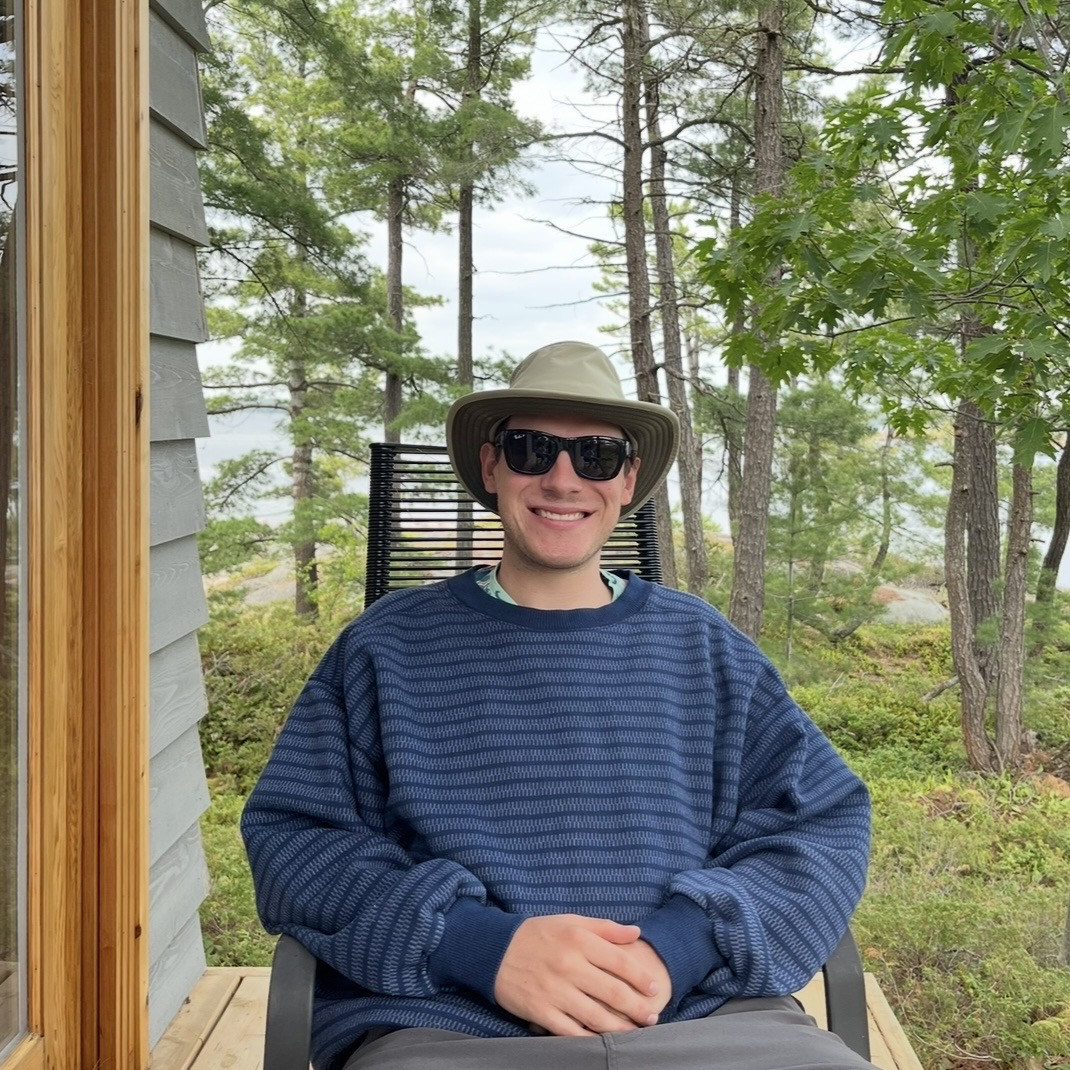 Ben Saul sitting outdoors by the water
